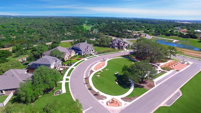 aerial perspective of suburban area with a nearby body of water and a forest