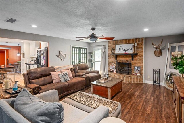 1619 Twin Island Dr, Lockhart, TX 78644 - living area featuring ceiling fan, a textured ceiling, dark wood-type flooring, a fireplace, and recessed lighting