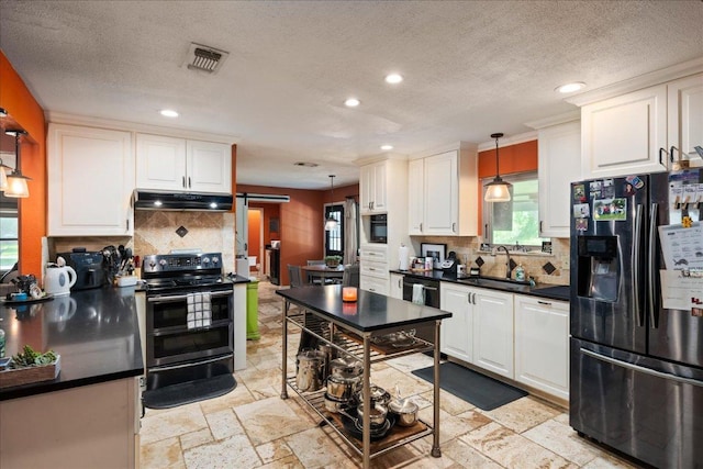 1619 Twin Island Dr, Lockhart, TX 78644 - kitchen with refrigerator with ice dispenser, double oven range, a sink, recessed lighting, and under cabinet range hood