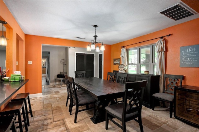 1619 Twin Island Dr, Lockhart, TX 78644 - dining room featuring stone tile flooring, a chandelier, and baseboards