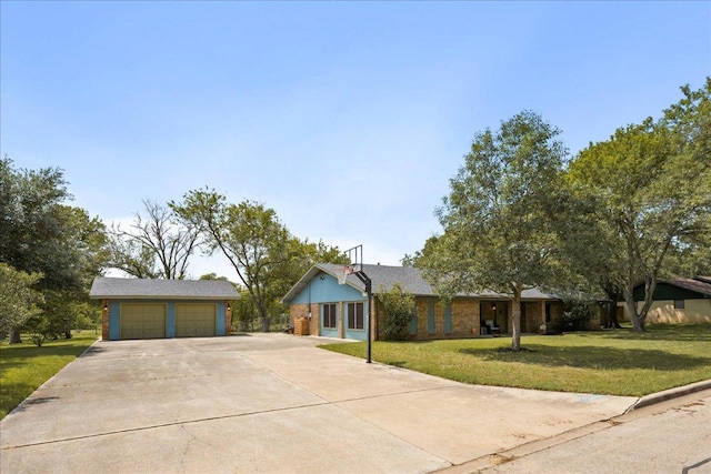 single story home with a garage, a front lawn, concrete driveway, and an outdoor structure