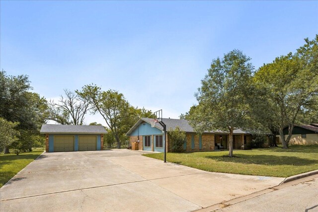 1619 Twin Island Dr, Lockhart, TX 78644 - ranch-style house with a garage, concrete driveway, a front lawn, and an outdoor structure
