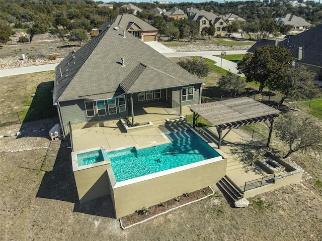 view of swimming pool with a patio area, a pool with connected hot tub, and fence