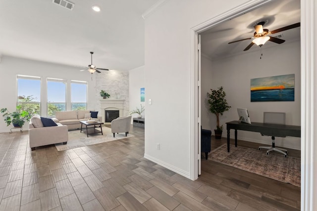 living room featuring ceiling fan, baseboards, wood finish floors, an office area, and a large fireplace