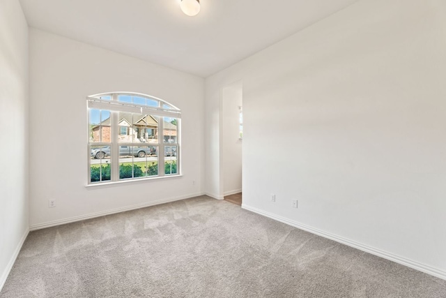 empty room featuring carpet flooring and baseboards