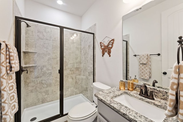 full bath featuring a stall shower, toilet, and vanity