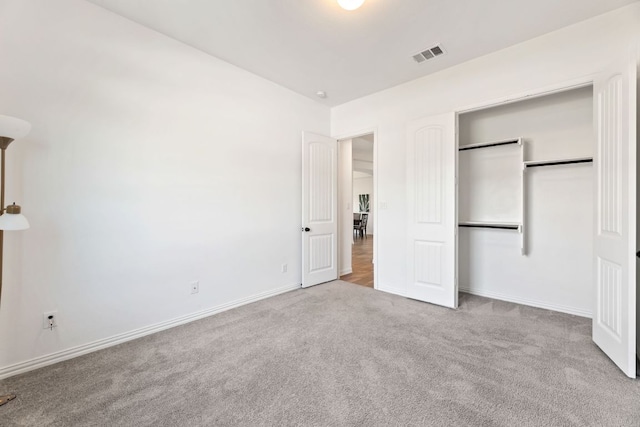unfurnished bedroom with carpet floors, baseboards, and a closet