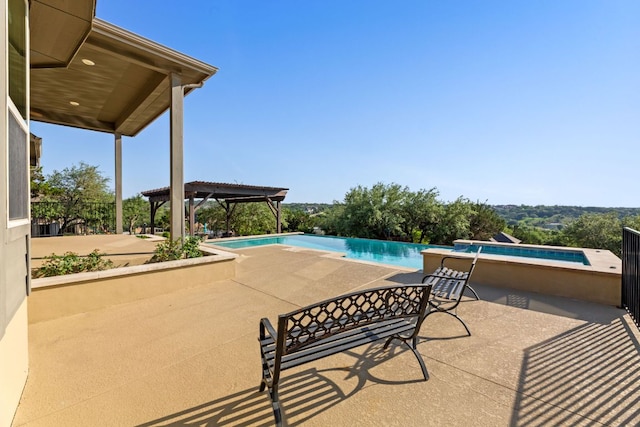 view of pool with a jacuzzi, a patio area, and an infinity pool