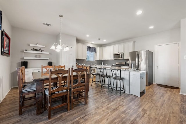 651 Bayberry Cir, Buda, TX 78610 - dining area with wood finished floors, a chandelier, baseboards, and recessed lighting