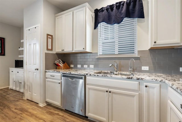 651 Bayberry Cir, Buda, TX 78610 - kitchen featuring dishwasher, a sink, tasteful backsplash, light wood-style flooring, and white cabinets