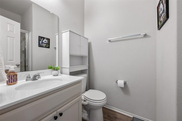 651 Bayberry Cir, Buda, TX 78610 - bathroom featuring toilet, vanity, wood finished floors, baseboards, and an enclosed shower
