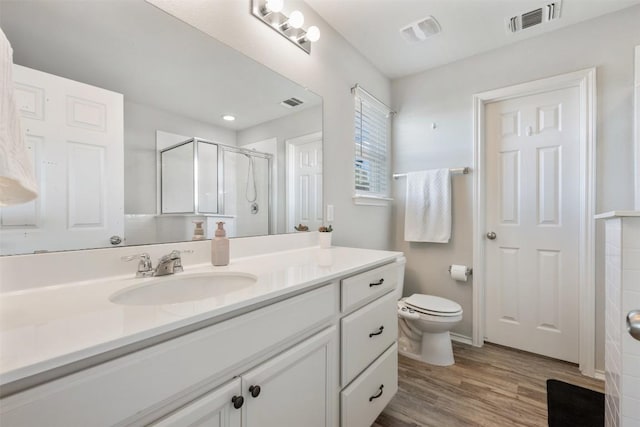 651 Bayberry Cir, Buda, TX 78610 - bathroom featuring a stall shower, toilet, wood finished floors, and vanity