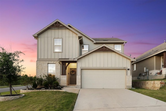 651 Bayberry Cir, Buda, TX 78610 - view of front of home with concrete driveway, a garage, stone siding, a front yard, and board and batten siding