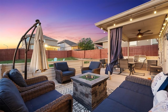 651 Bayberry Cir, Buda, TX 78610 - patio terrace at dusk with an outdoor living space with a fire pit, a fenced backyard, a ceiling fan, and area for grilling