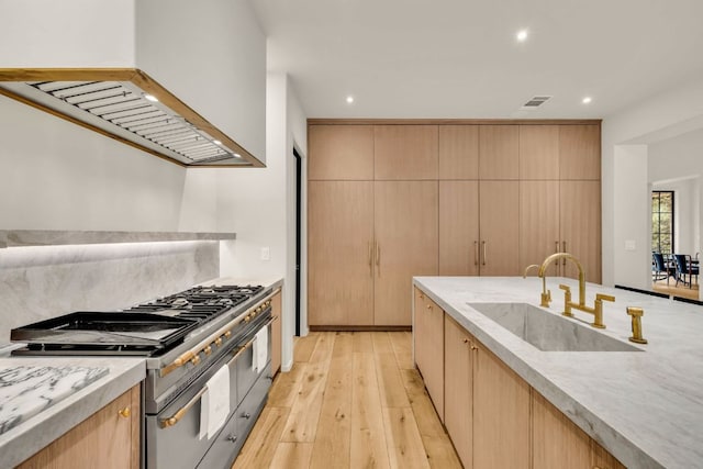 3204 Aztec Fall Cv, Austin, TX 78746 - kitchen featuring a sink, range with two ovens, custom exhaust hood, recessed lighting, and light wood finished floors