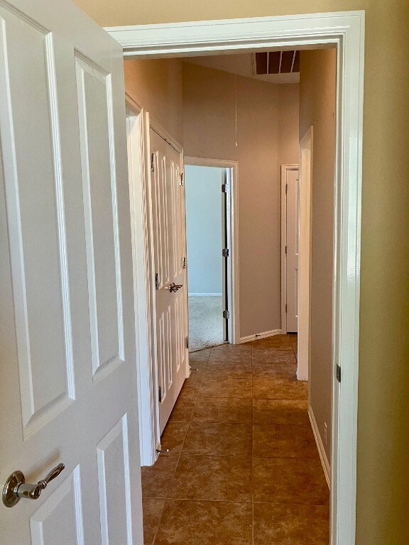 209 Country Creek Dr, Austin, TX 78737 - corridor with dark tile patterned floors and attic access