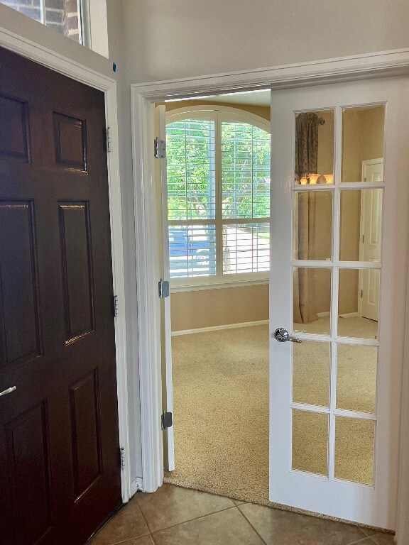 209 Country Creek Dr, Austin, TX 78737 - entryway with tile patterned flooring, carpet flooring, and baseboards