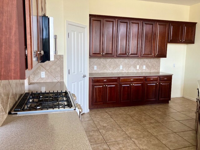 209 Country Creek Dr, Austin, TX 78737 - kitchen featuring light countertops, decorative backsplash, gas range, cooktop, and dark brown cabinets