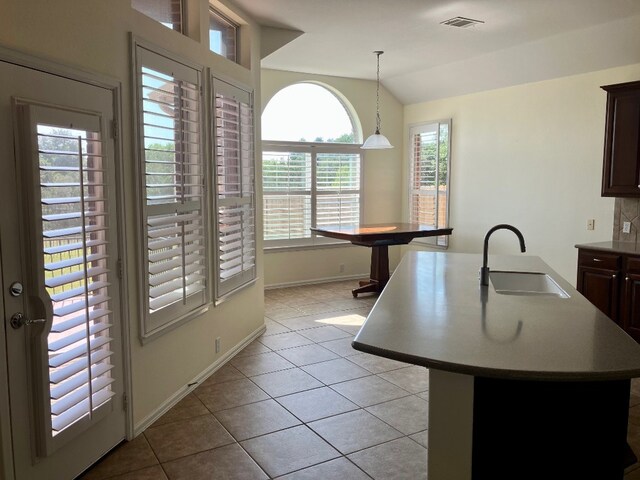 209 Country Creek Dr, Austin, TX 78737 - kitchen featuring a sink, lofted ceiling, light tile patterned flooring, decorative light fixtures, and baseboards