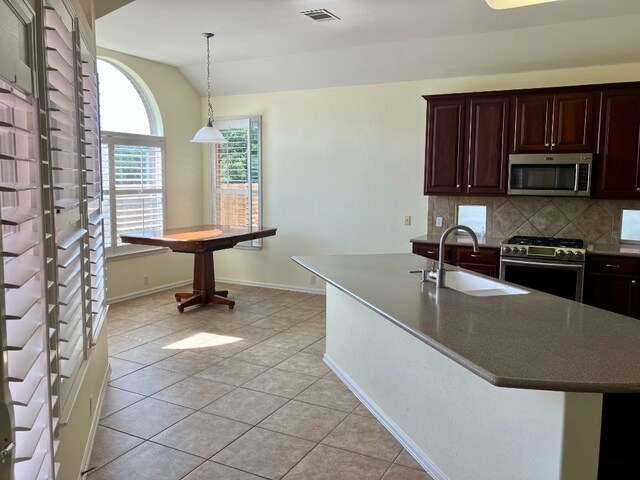 209 Country Creek Dr, Austin, TX 78737 - kitchen with appliances with stainless steel finishes, a sink, vaulted ceiling, tasteful backsplash, and light tile patterned floors