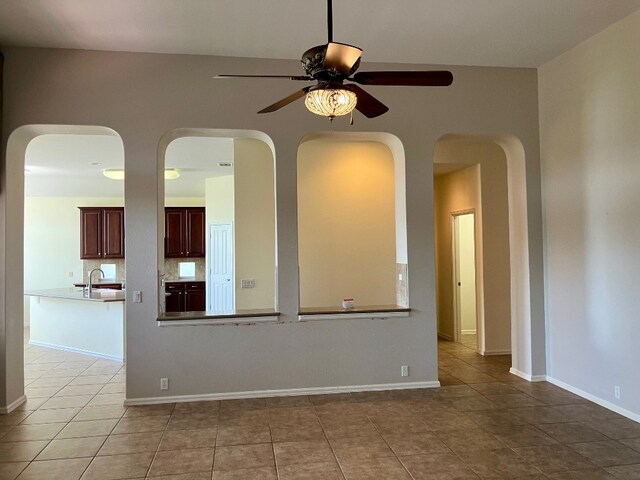209 Country Creek Dr, Austin, TX 78737 - tiled spare room featuring a ceiling fan, a sink, arched walkways, and baseboards