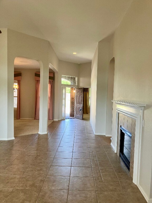 209 Country Creek Dr, Austin, TX 78737 - tiled foyer entrance featuring a tile fireplace, arched walkways, and baseboards