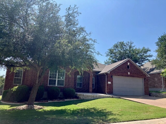 209 Country Creek Dr, Austin, TX 78737 - view of front of house with an attached garage, a front lawn, concrete driveway, and brick siding