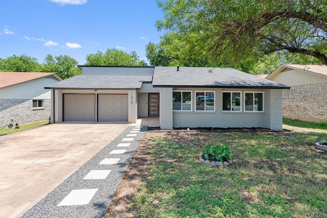 10107 E Rutland Vlg, Austin, TX 78758 - view of front of house with an attached garage, brick siding, concrete driveway, and a front yard
