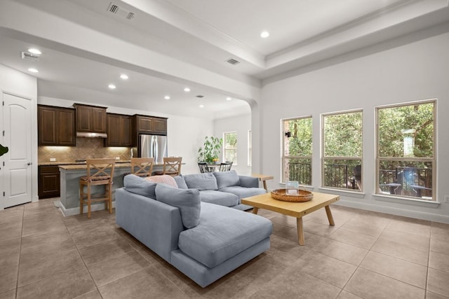 living area with recessed lighting, arched walkways, and light tile patterned flooring