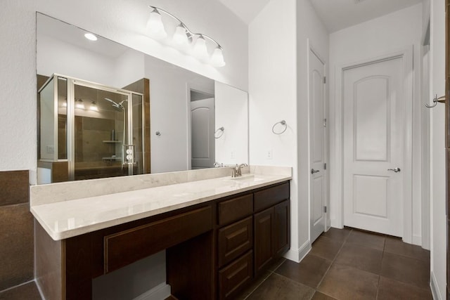 bathroom with a stall shower, vanity, and tile patterned floors