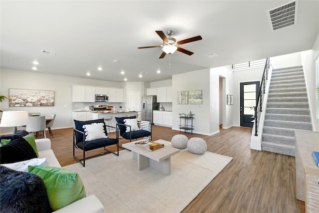 10207 Buster Dr, Austin, TX 78748 - living room with light wood-style flooring, ceiling fan, recessed lighting, stairway, and baseboards