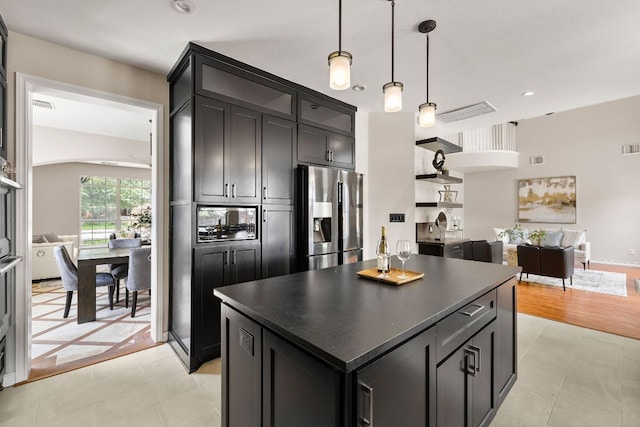 701 Stansted Manor Dr, Pflugerville, TX 78660 - kitchen with appliances with stainless steel finishes, dark countertops, a center island, hanging light fixtures, and light tile patterned flooring