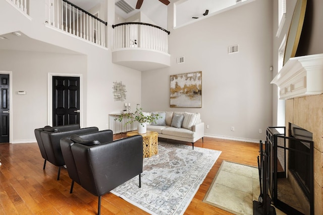 701 Stansted Manor Dr, Pflugerville, TX 78660 - living area featuring a fireplace, a high ceiling, wood finished floors, a ceiling fan, and baseboards