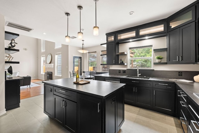 701 Stansted Manor Dr, Pflugerville, TX 78660 - kitchen featuring open shelves, dark cabinets, dark countertops, a center island, and light tile patterned floors