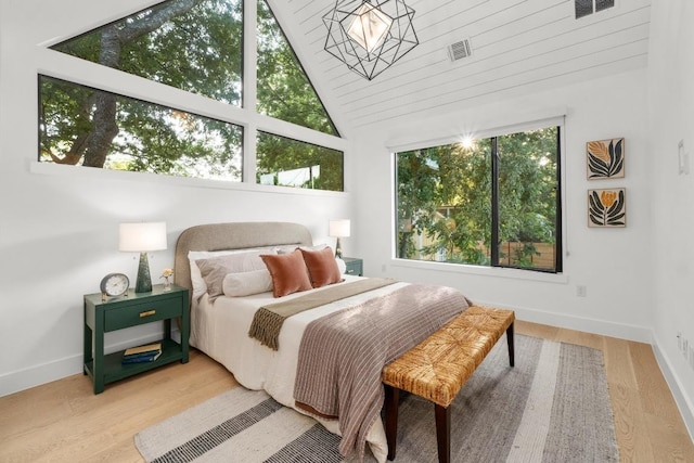 bedroom featuring vaulted ceiling, baseboards, and wood finished floors
