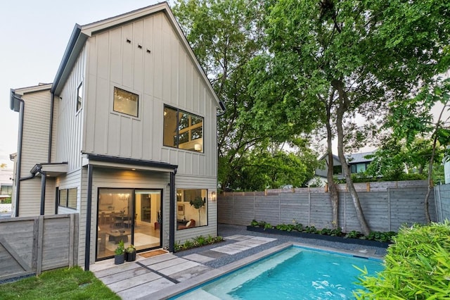 rear view of property featuring board and batten siding and a fenced backyard