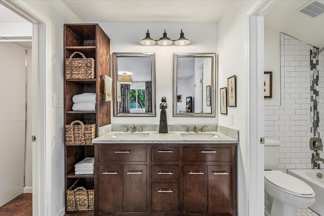 bathroom with toilet and double vanity