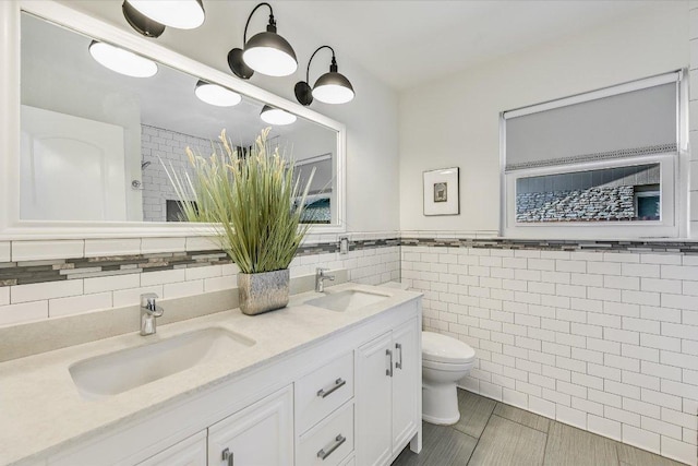 6201 Sun Vista Dr, Austin, TX 78749 - full bathroom with tile walls, toilet, and double vanity