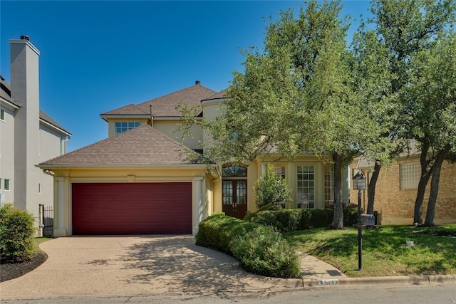 5133 Valburn Ct, Austin, TX 78731 - view of front of house with an attached garage, driveway, a shingled roof, and stucco siding