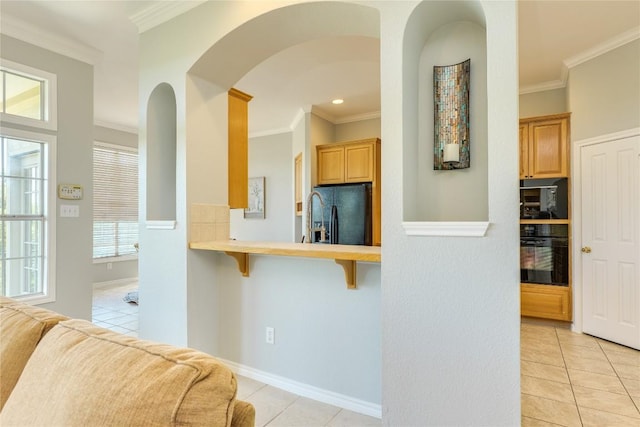 5133 Valburn Ct, Austin, TX 78731 - kitchen with black appliances, light tile patterned flooring, a breakfast bar, arched walkways, and crown molding
