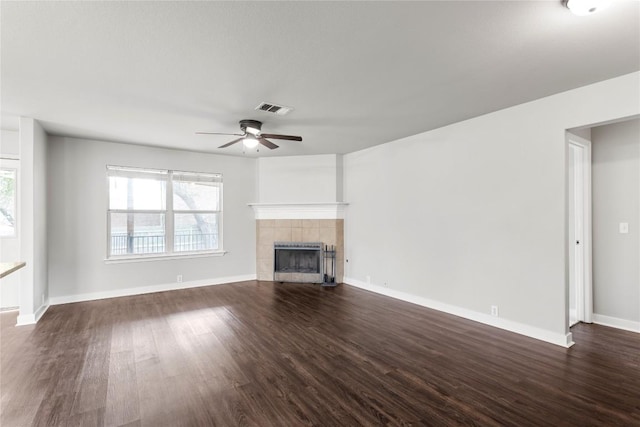 1600 Gretchen Dr, Cedar Park, TX 78613 - unfurnished living room featuring dark wood-style flooring, a ceiling fan, a tiled fireplace, and baseboards