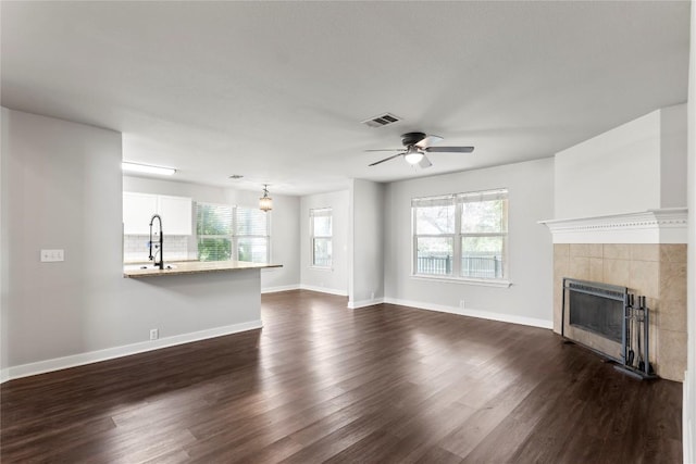 1600 Gretchen Dr, Cedar Park, TX 78613 - unfurnished living room with a tile fireplace, dark wood-style floors, ceiling fan, and baseboards