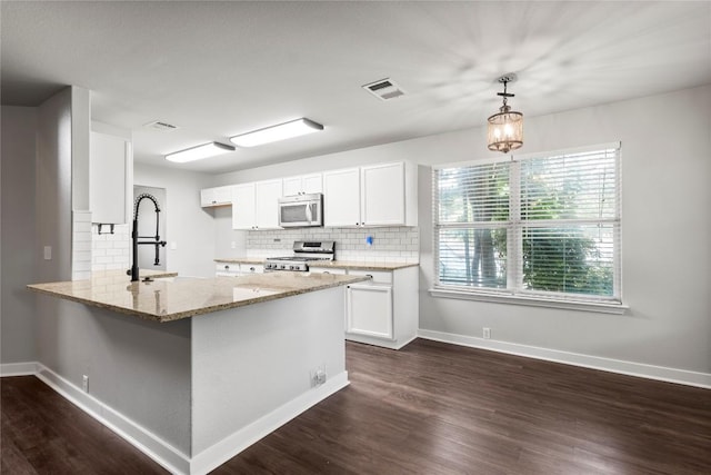 1600 Gretchen Dr, Cedar Park, TX 78613 - kitchen with appliances with stainless steel finishes, light stone countertops, decorative backsplash, white cabinetry, and a peninsula
