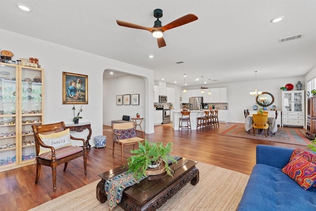 7609 Lazy Creek Dr, Austin, TX 78724 - living area with wood finished floors, ceiling fan, arched walkways, recessed lighting, and a chandelier