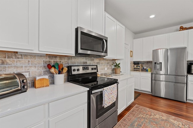 7609 Lazy Creek Dr, Austin, TX 78724 - kitchen with stainless steel appliances, light countertops, white cabinetry, dark wood-style floors, and recessed lighting