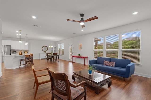 7609 Lazy Creek Dr, Austin, TX 78724 - living room featuring a ceiling fan, wood finished floors, recessed lighting, and a chandelier
