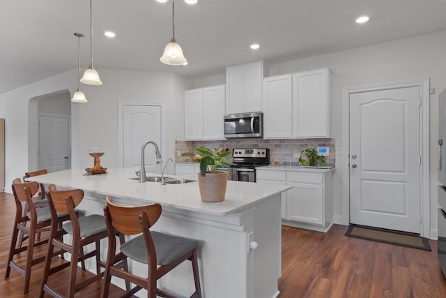 7609 Lazy Creek Dr, Austin, TX 78724 - kitchen with stainless steel appliances, decorative backsplash, a breakfast bar, dark wood-style floors, and recessed lighting