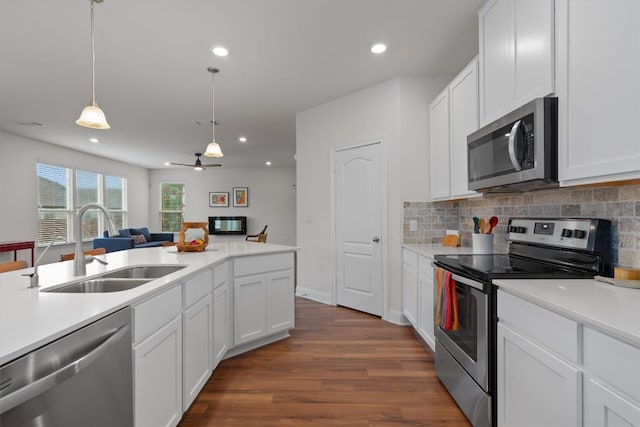 7609 Lazy Creek Dr, Austin, TX 78724 - kitchen featuring appliances with stainless steel finishes, dark wood-style floors, recessed lighting, light countertops, and backsplash