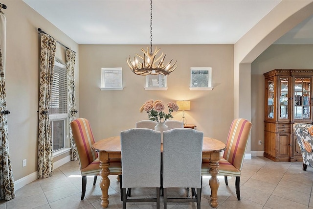 937 Wild Rose Dr, Austin, TX 78737 - dining space featuring a chandelier, light tile patterned floors, arched walkways, and baseboards