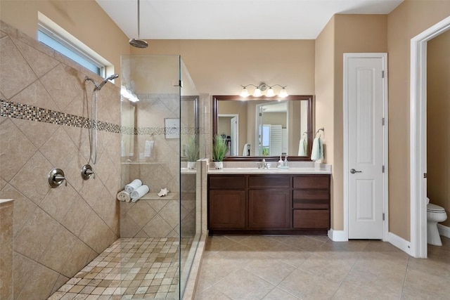 full bath featuring tiled shower, toilet, tile patterned flooring, and vanity